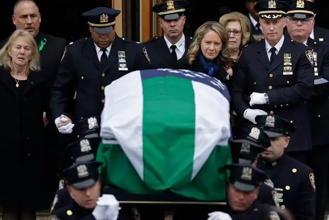 Leanne Simonsen, the widow of Det. Brian Simonsen, follows his casket from the Church of St. Rosalie in Hampton Bays, N.Y.